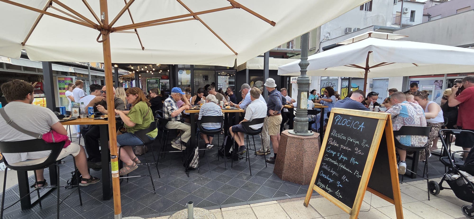 Full terrace at the Tržnica — guests at lunch outside Pločica.